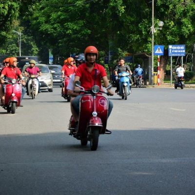“Zip through the city’s buzzing streets where scooters swarm, vendors call, and every corner bursts with motion and color.”